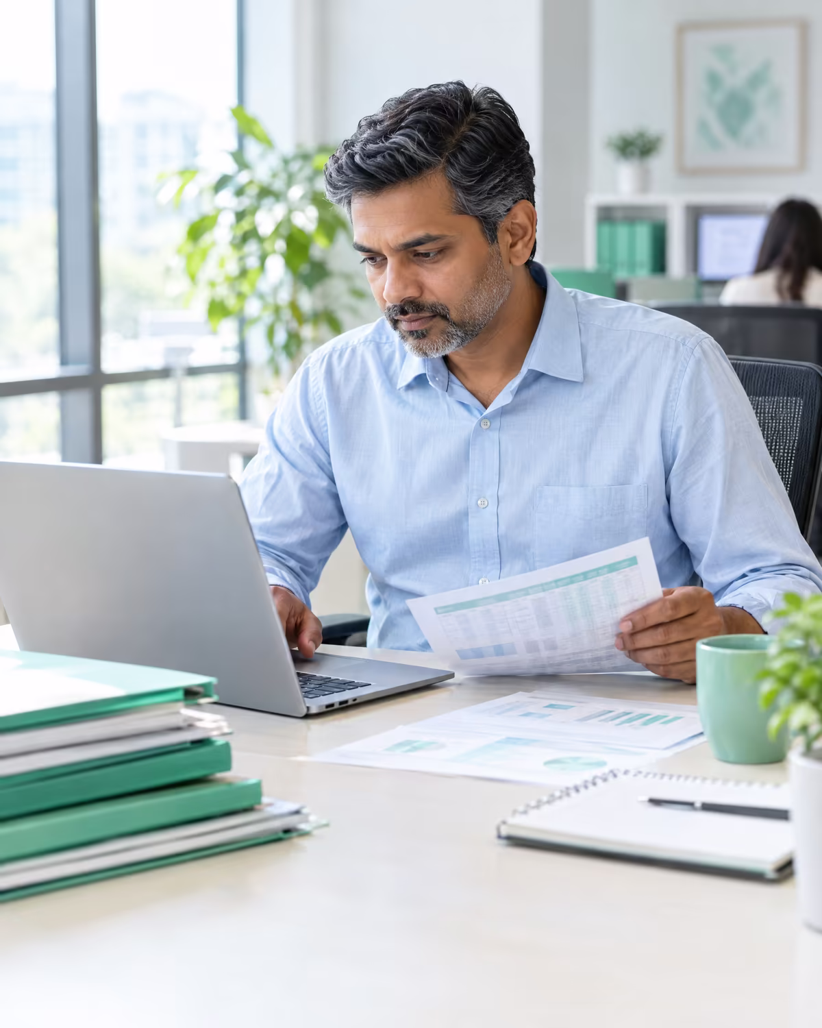 A back-office specialist reviewing invoices and spreadsheets